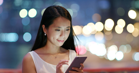 Woman look at smart phone at night