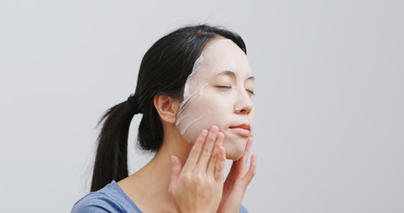 Young Woman apply face mask on face at home