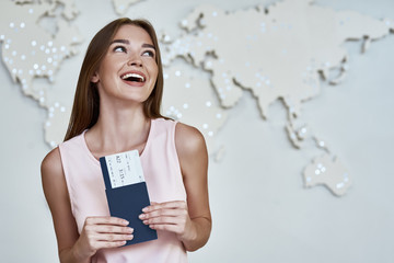 Happy young woman with passports and tickets in the office of travel company