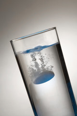 EFFERVESCENT TABLET DISSOLVING IN GLASS TUMBLER OF WATER