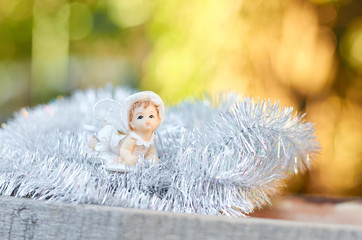 angel sits in a silver background
