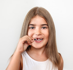 Small girl holding tooth