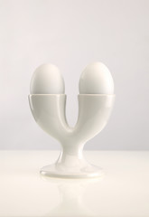 TWO WHITE EGGS IN DOUBLE WHITE EGG CUP