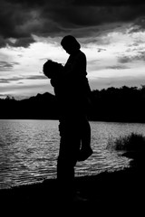 silhouette of romantic lovers with river in thailand with sunset. black and white