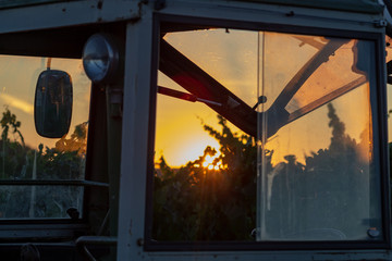 Feierabend Stimmung auf dem Weinberg mit dem Sonnenuntergang durch das Traktor Cockpit