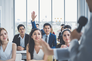 Business man raising hand for asking speaker for question and answer concept in meeting room for seminar