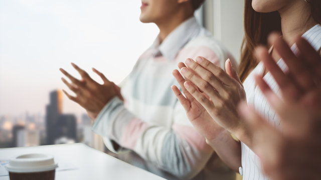 Young business people clapping hands during meeting in office for their success in business work