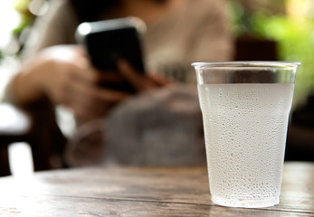 glass of water with drop water on the wooden table.