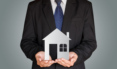 Businessman holding paper house in his hands, Real estate concept