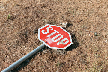 Stop traffic sign hit broken damaged on the ground diagonal