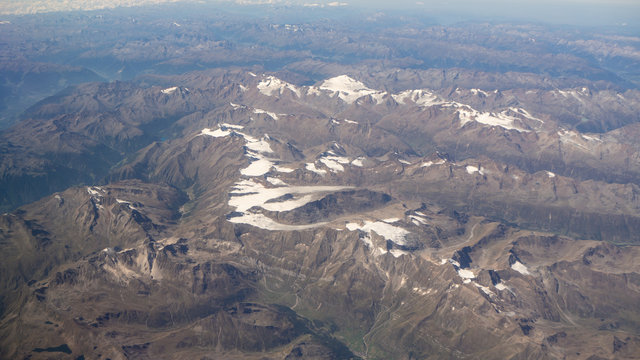 Fototapeta Flying over the European Alps during summer season. Landscape at the glaciers. Aerial view from the airplane window
