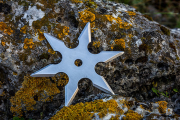 Shuriken (throwing star), traditional japanese ninja cold weapon stuck in wooden background