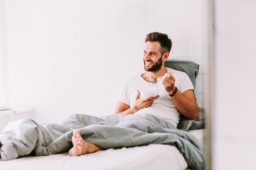 Young man eating breakfast in bed
