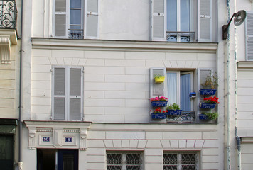 Fototapeta na wymiar Building facades with flowers on windows in Montmartre, Paris
