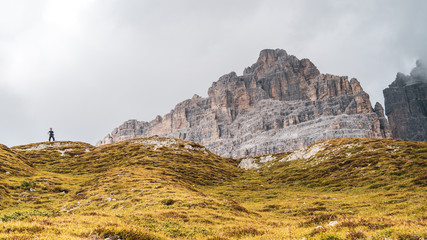 Orizontal shot of the three peaks of lavaredo (drei zimmen, tre cime) from behind and from the back (the side of Auronzo refuge). The peaks are cutting through clouds 