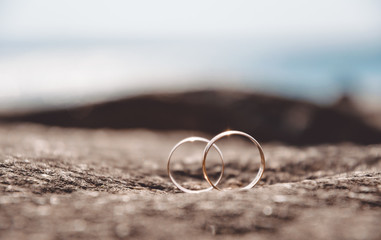 Gold wedding rings on a background of a sea landscape