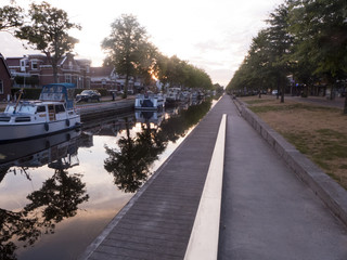 Abendstimmung an einem Kanal in Stadskanaal in Niederland. Die Bäume und Boote spiegeln sich im Wasser.