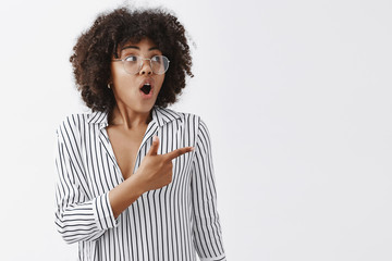 Waist-up shot of impressed and excited african american businesswoman with afro hairstyle in...