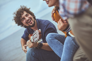 Heartwarming melody. Portrait of musician singing a song to his friends while playing the guitar