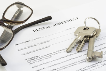 rental agreement document with a set of house keys and glasses