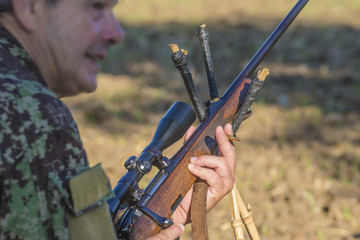 Hunter loading the carbine with optical sight on the hunting
