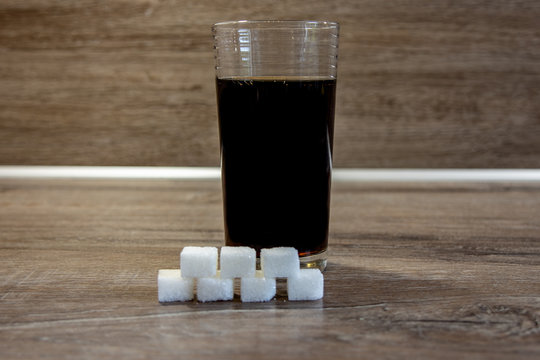 Bild von einem 200ml Glas Cola und 7 St&uuml;ck W&uuml;rfelzucker die in dem Getr&auml;nk dieser Gr&ouml;&szlig;e enthalten ist.