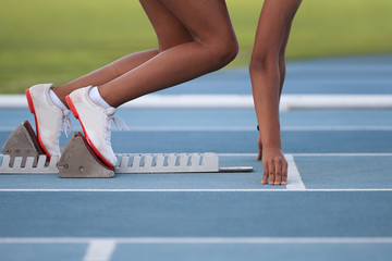 Woman in a starting block on an athletic field