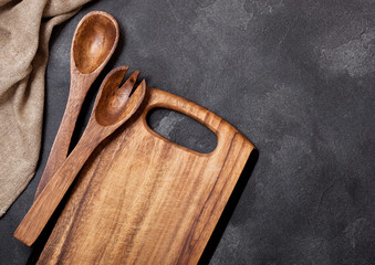Vintage kitchen wooden utensils with chopping board on stone table background. Top view. Space for text