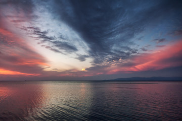 Bright colorful pink and blue sunset, tropical sea nature background and texture, the sky is reflected in the water