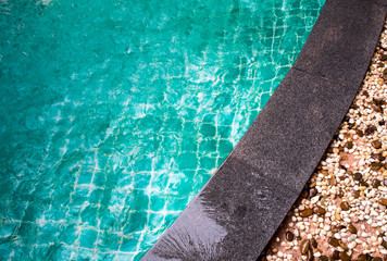 Bright blue water and the black granite edge of swimming pool