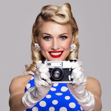 woman, with no-name camera, taking picture, dressed in pin-up style