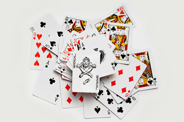 Royal flush playing cards with joker, randomly displaced. Isolated on white background.