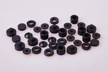 Black hydraulic and pneumatic o-ring seals of different sizes scattered a white background. Rubber rings. Sealing gaskets for hydraulic joints. Rubber sealing rings for plumbing. Top view