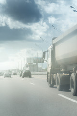 Naklejka na ściany i meble dump truck on highway in sunny day and clouds