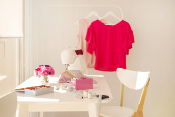 Workplace for sewing and needlework in a bright room with white furniture.