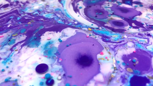 Abstract colorful bubbles marble background with milk oil and soap. Colored inks react to a drop of liquid soap in the oil. 