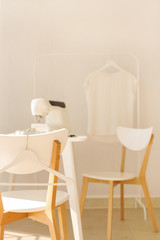 Workplace for sewing and needlework in a bright room with white furniture.