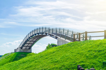 Arched bridge between two green hills