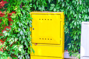 Yellow metal box installed on the street, utilities, electricity, gas