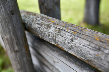 Fototapeta premium Surface of old wooden sticks arranged herringbone. Wooden fence close up background. Old wooden fence on the sand.
