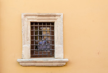 Small window with a metal grille in an old house