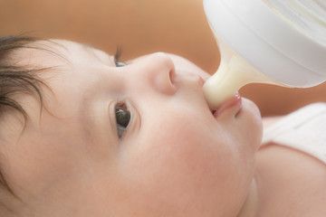 baby infant eating milk from bottle, 9 months after birth