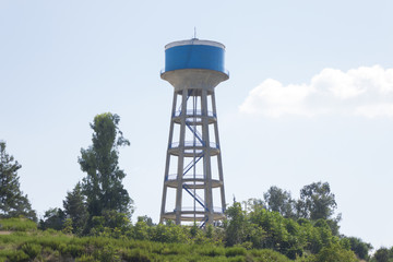 Water tower painted blue under blue sky