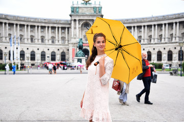 VIENNA, AUSTRIA. A girl with a yellow umbrella on the background of the Neue Burg, a new castle of...