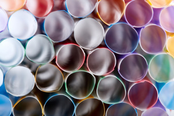 Striped, colored tubes for cocktails. Colorful background.