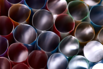 Striped, colored tubes for cocktails. Colorful background.