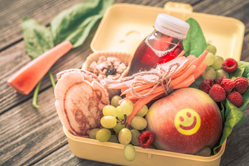 Breakfast or lunch with healthy food in a yellow box, on a wooden background.
