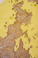 Old wall with peeling yellow tint