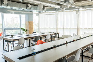 Bright and spacious conference hall with long negotiating table and chairs in office