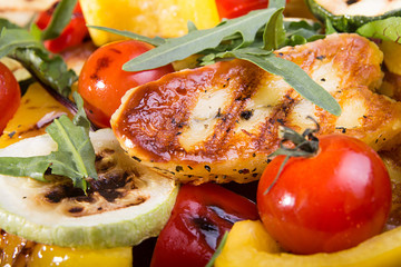 Grilled roasted halloumi cheese with grilled cherry tomato, pepper, zuccini. Tasty snack close up.